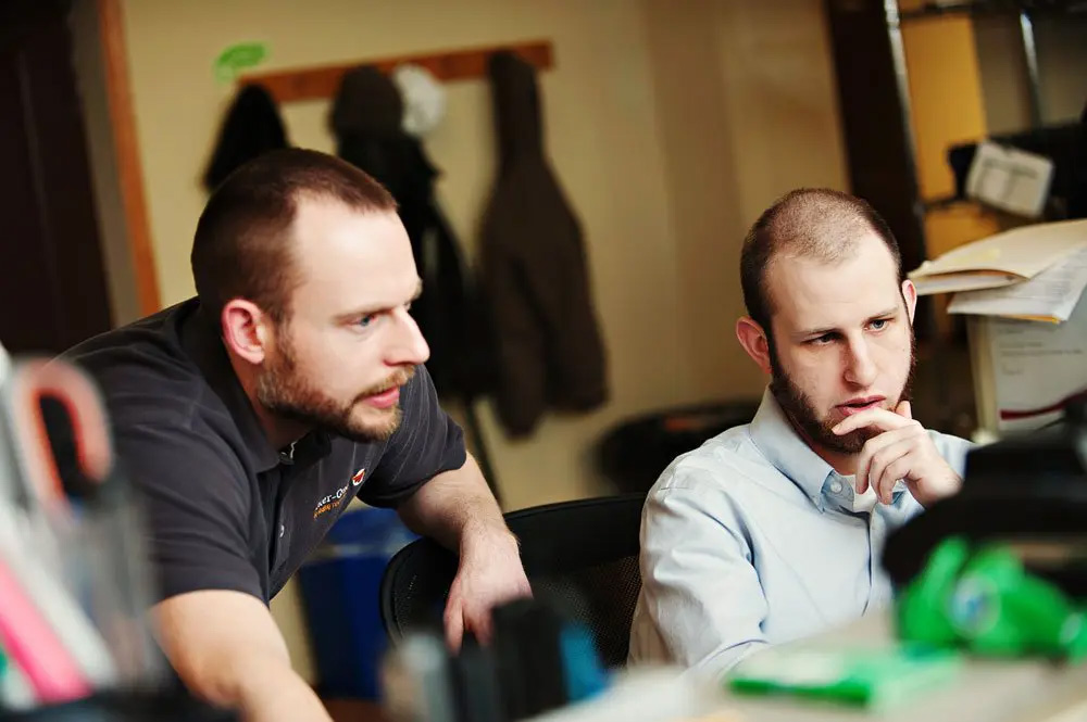 People discussing while looking at a computer
